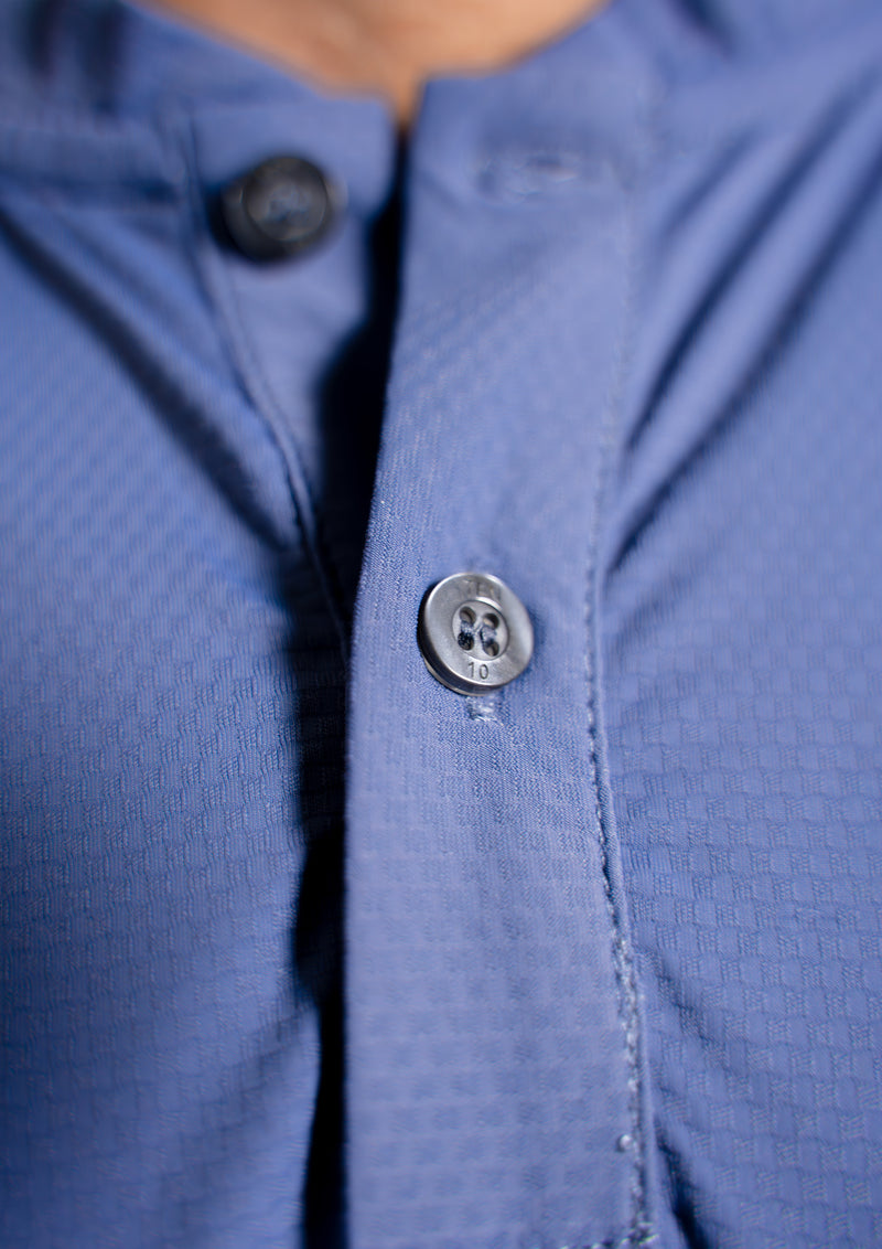 close up view of a meridian blue mock neck polo showing engraved buttons