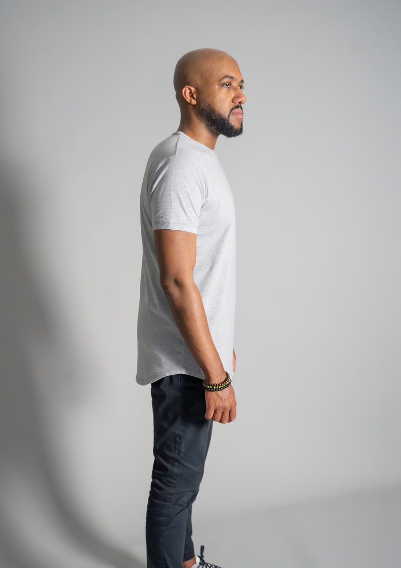 Side view of male model in a fossil gray short sleeve curved bottom tee