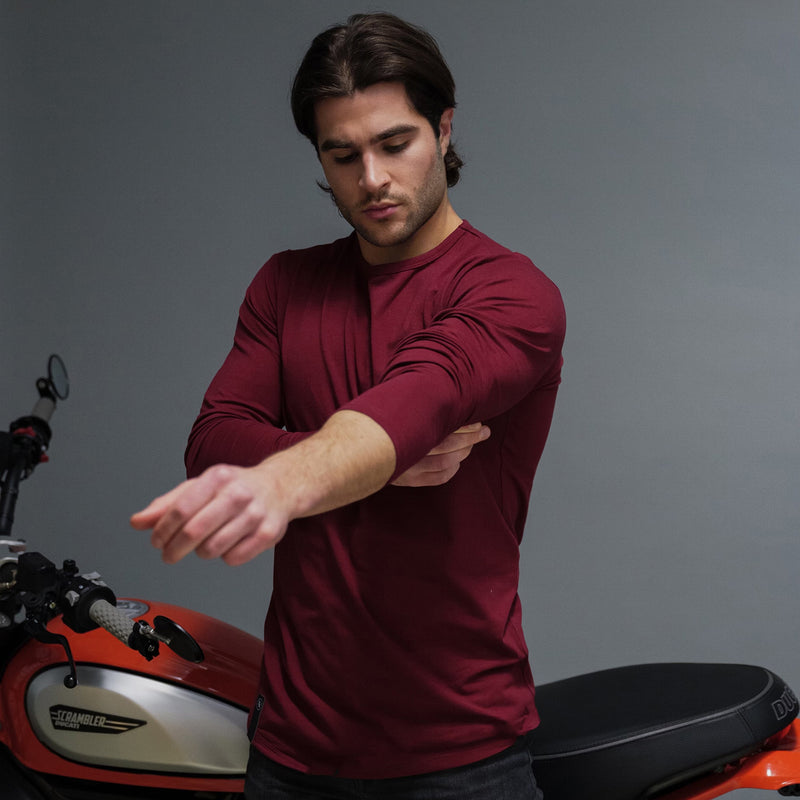 Male model in dark red men's long sleeve casual shirt with a curved U bottom cut