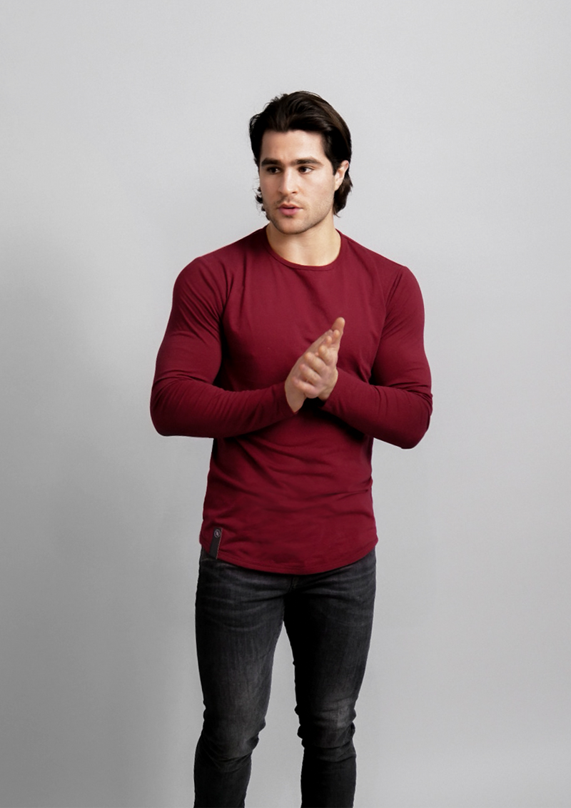 Male model in a dark red mahogany long sleeve ten out of ten athletic fit shirt with hand rubbing each other