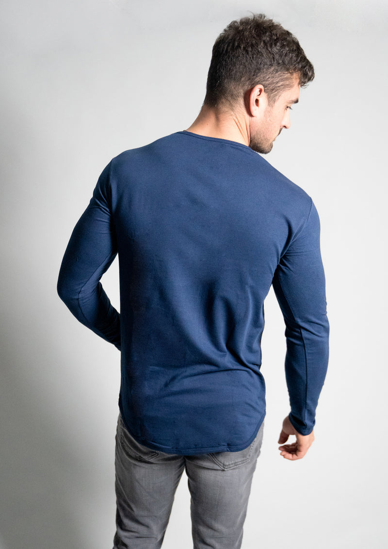 Full back view of model in Ten/10 apparel mens long sleeve crew neck tee with curved hem bottom