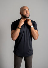 Male model in a black mock neck polo with a curved hem bottom from Ten10 Apparel