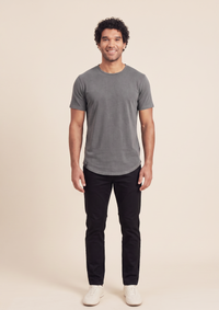 man in gray short sleeve luxury curved hem tee with blank pants and biege shoes on