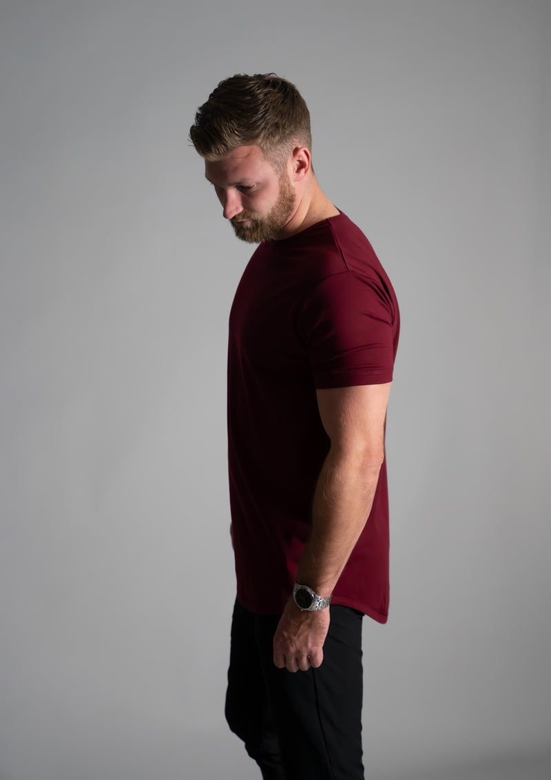 Athletic male model in red curved hem shirt from ten10 apparel
