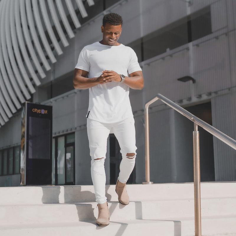 African American Male Model walking down steps in a white crew neck drop cut t-shirt 