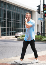 Man walking across the street in New Orleans in the mist color shirt short sleeve