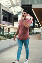 Male model with dark hair walking in Ten out of Ten apparel's rosewood colored shirt through a downtown Brickell Centre mall
