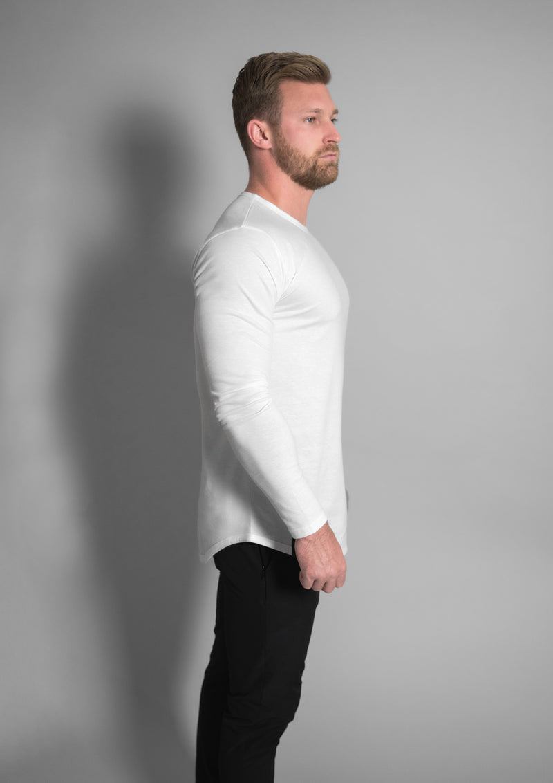 Mens model in a curved hem white long sleeve shirt that is crew neck
