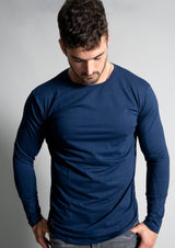 Male model in a navy blue long sleeve looking down with muscular physique from ten/10 apparel