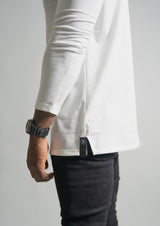 close up view of white split hem long sleeve shirt showing just the bottom portion with the leather hem tag