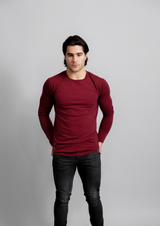 Male model in a dark red mahogany long sleeve ten out of ten shirt with arms to his hips